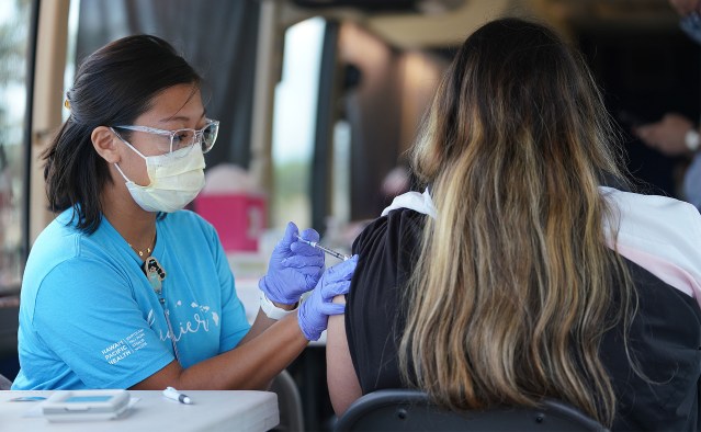 Crystal Alfonso RN gives a student her COVID-19 vaccination at Ilima Intermediate School.