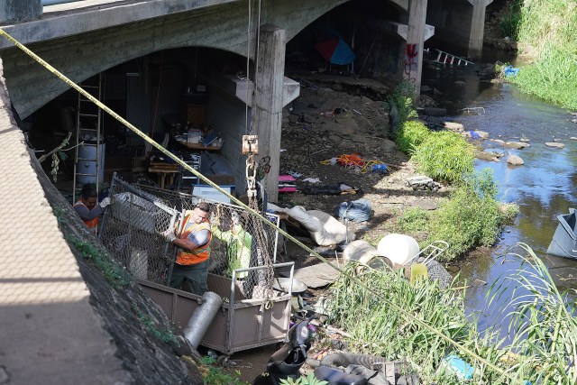 City workers assist in clearing homeless camp under a bridge located under the Kapiolani Boulevard / Manoa Palolo Drainage Canal. This area is located across Kaimuki High School.