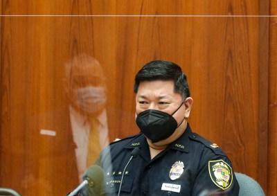 Honolulu police Lt. Brandon Nakasone listens to questions from defense attorney Richard Sing, reflected in the plexiglass barrier, in the district courtroom of Judge William M. Domingo during preliminary hearings for three Honolulu police officers in the killing of Iremamber Sykap on Tuesday, Aug. 17, 2021, in Honolulu. (POOL PHOTO/Jamm Aquino/Honolulu Star-Advertiser).
