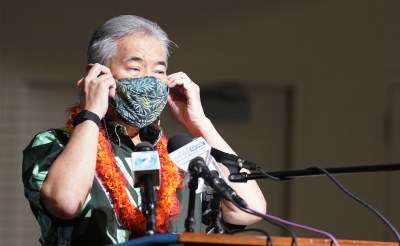 Governor David Ige prepares to remove mask before speaking at Prince David Kawananakoa Middle School press conference on the opening of schools for in person instruction.