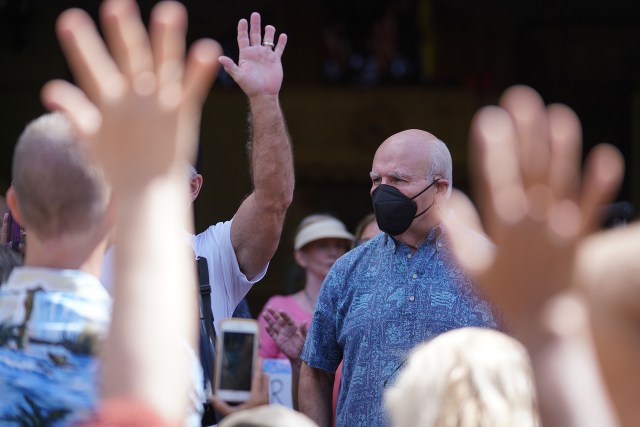 Unmasked members from the Aloha Freedom Coalition raise their hands to ask Mayor Rick Blangiardi questions fronting Honolulu Hale.