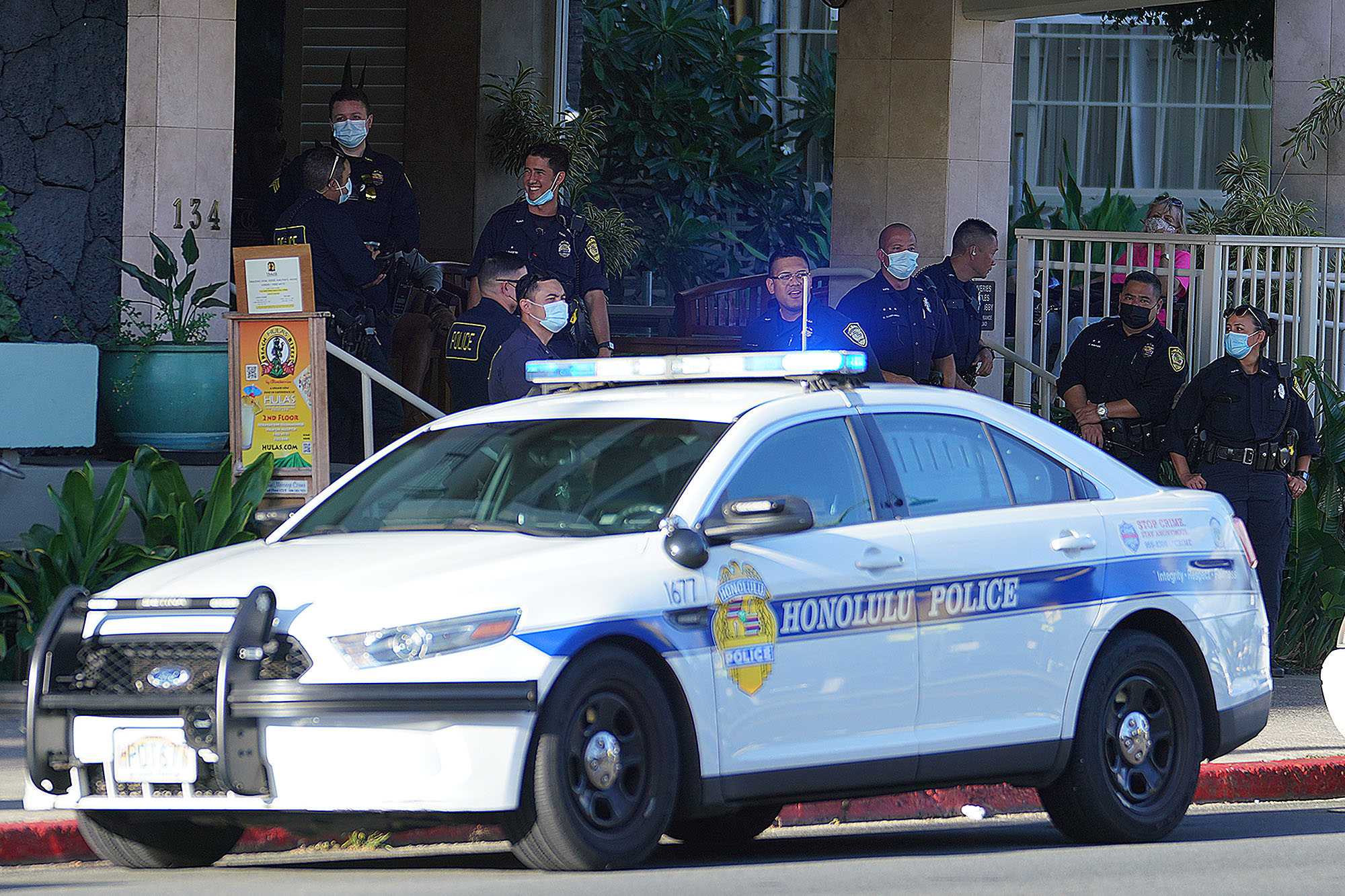 Honolulu Police officers wait along Kapahulu Avenue before the Aloha Freedom Coalition march starts from the Honolulu Zoo.