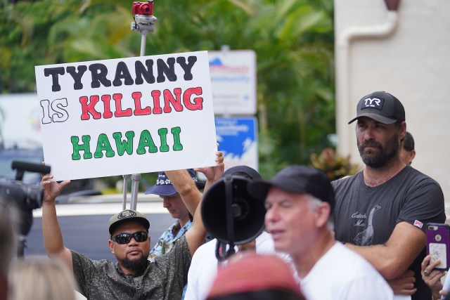 Aloha Freedom Coalition supporters holds a sign while questioning Mayor Rick Blangiardi at Honolulu Hale. September 1, 2021.