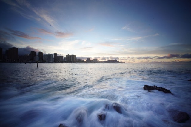Waves churn along the rocks at Magic island with a beautiful sunrise.