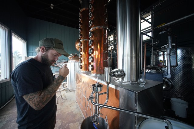 Kohana Hawaiian Agricole Rum Distillery Manager Tyler Johnson stands with the ‘Hybrid Still’ as it distills to make one of their Rums.