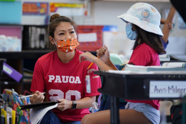 Pauoa Elementary School 3rd grade teacher Kristin Tatemichi works with her students during class.