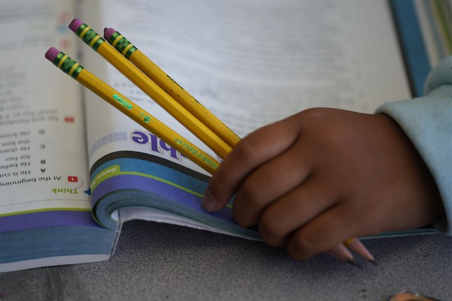 Pauoa Elementary School 3rd grade Teacher Kristin Tatemichi teaches in class. Closeup of a student holding pencils.