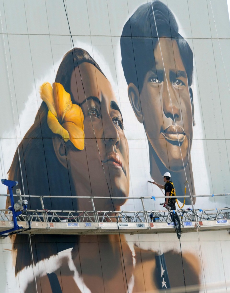 Artist Kamea Hadar work to complete a mural of Carissa Moore and Duke Kahanamoku between the 10th and 11th floor. on a building off King Street and Pensacola. in Honolulu Tuesday, October 26, 2021. (Ronen Zilberman photo Civil Beat)
