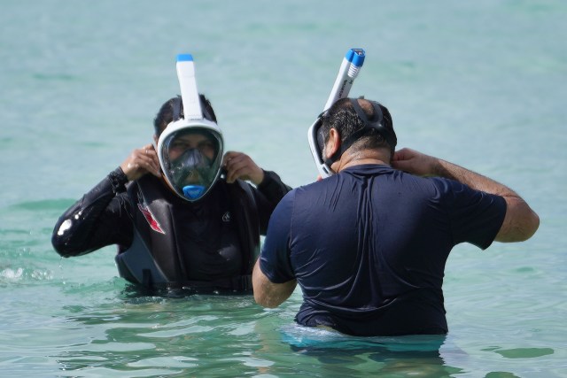 Swimmers use full face snorkel masks at Kaimana Beach.