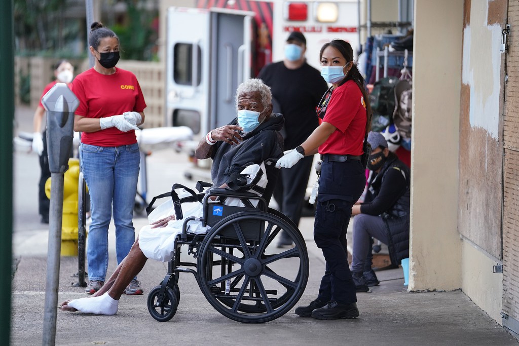 Office of Housing CORE EMT Jolene Chun assists Johnny Roberts after he was cleaned up at IHS. Mr. Roberts was then taken to the Veterans Affairs Urgent Care at Tripler Hospital.