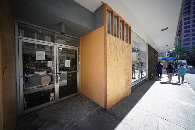 Wood sheets block out the broken window at GInger 13 located on Pauahi Street.