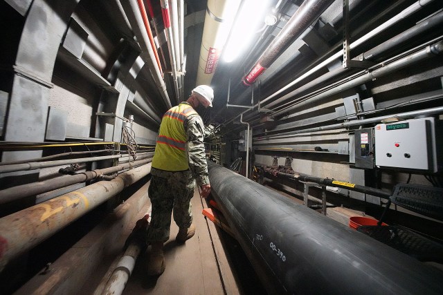 Lt. Commander Travis Myers walks in tunnel leading to the Red Hill well. The pipe at right will pump up to 5 million gallons of contaminated water to 8 tanks that contain granulated carbon to filter the contaminants and then be discharged into the Halawa Stream.