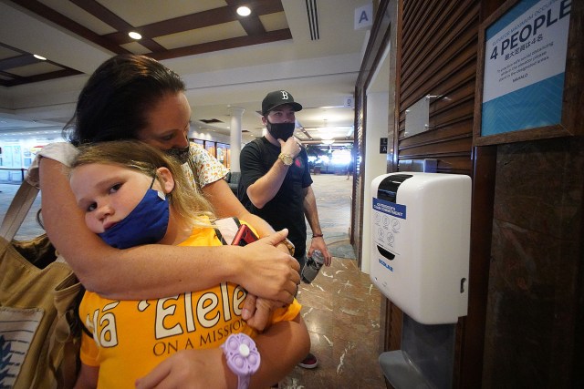 Left, Christine Robert hugs her daughter left, Elissa Cook as she waits for the elevator at the Outrigger Hotel with son Christian Cook looking on . The family is living in the hotel due to Red Hill water issues at their housing at Halsey Terrace.