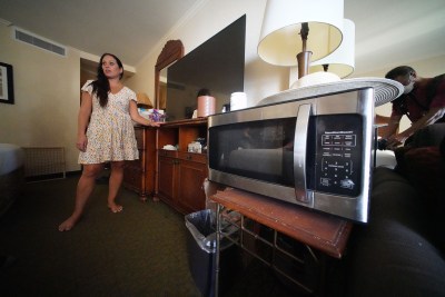 Christine Robert stands fronting a microwave that she brought to the hotel so she can warm up food. The family is living in the hotel due to Red Hill water issues at their housing at Halsey Terrace.