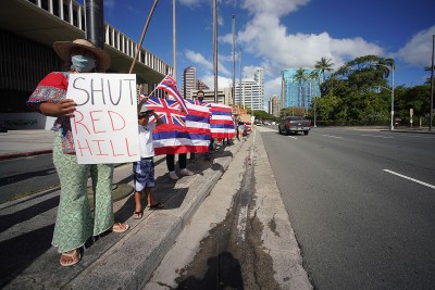 Demonstrators hold Hawaiian flags and signs calling for the closing of the Red Hill fuel tanks fronting the Capitol.