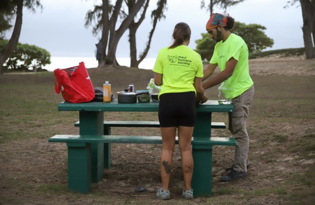 A photograph of Liz Woodall and Rashawn Hunter clearing up their dinner at Kanaha.