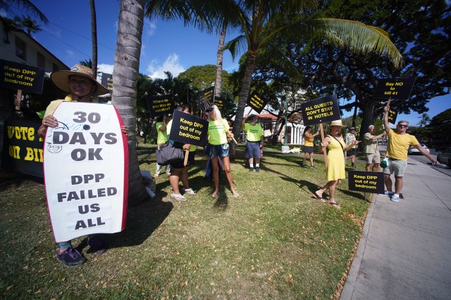 Demonstrators in opposition to Bill 41 hold signs on King Street near Honolulu Hale.