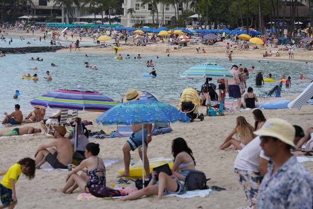 Beachgoers enjoy Waikiki Beach as tourism has returned and Covid-19 infection rates in Europe are spiking.