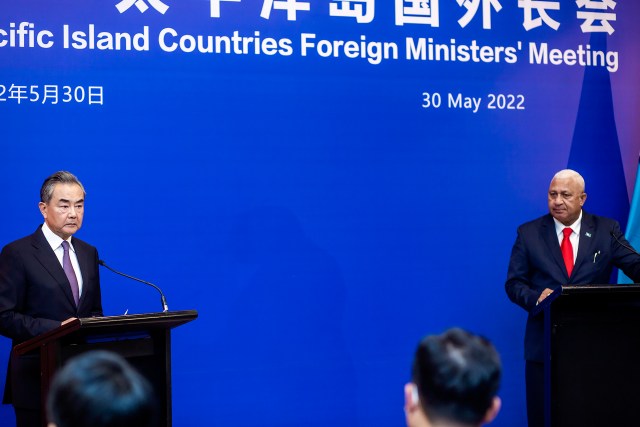China's Foreign Minister Wang Yi, left, appears on stage at the Pacific Islands Foreign Ministers' meeting with Fiji's Prime Minister Frank Bainimarama, Monday, May 30, 2022, in Suva, Fiji. (Leon Lord/Fiji Sun via AP)