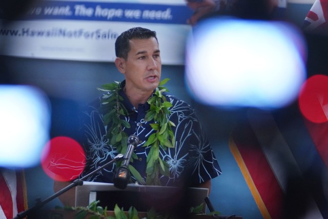 Kai Kahele announces running for Hawaii Governor at Hilo Boys and Girls Club gymnasium with foreground cameras and video equipment.