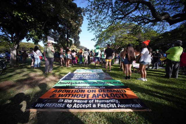 People gather near the entrance of the Honolulu Zoo for a rally and march to defend the right to abortion.