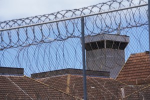Barbed wire fencing frames a guard tower located at OCCC Oahu Community Correctional Center.