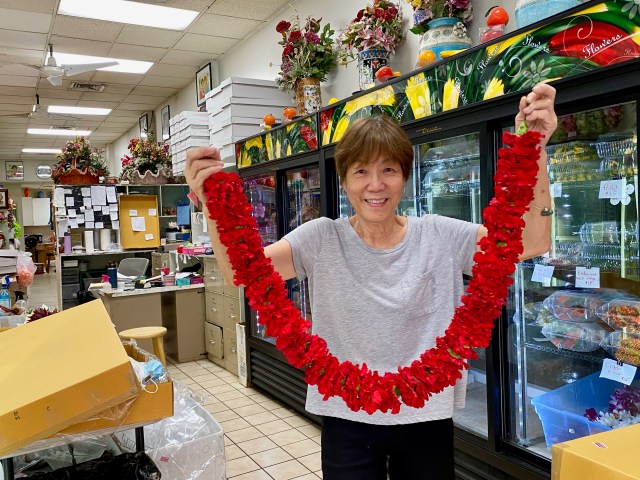 Karen Lee, manager of Cindy’s Lei and Flower Shoppe on Maunakea Street in Chinatown, with a freshly strung double red carnation lei. Karen is the daughter of Cindy Lau who has been selling lei in Chinatown for more than 50 years.