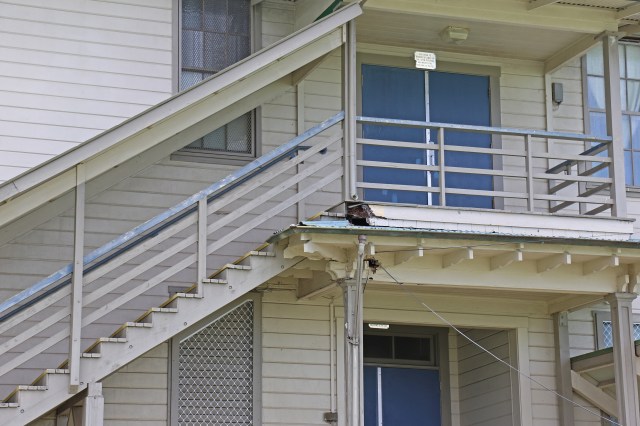 Wet rot damage is visible Tuesday next to a downspout on the top landing and support column at Hilo Intermediate's Building A, back stairway. The historic school opened in 1929. Photo: Tim Wright