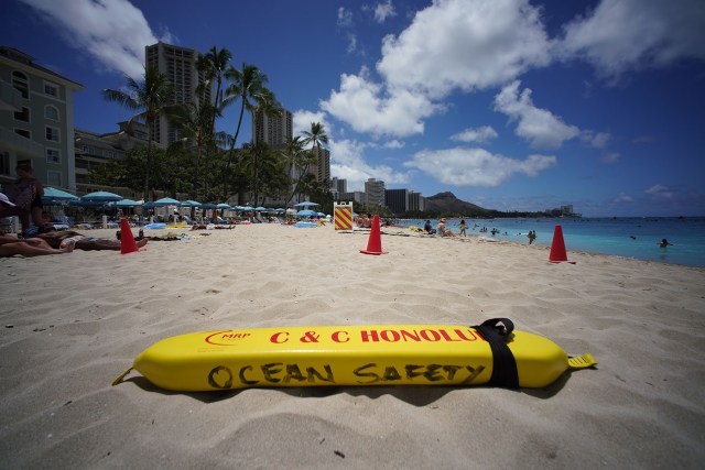 City and County Ocean Safety lifeguard rescue buoy on the sand fronting the lifeguard tower at Waikiki Beach.