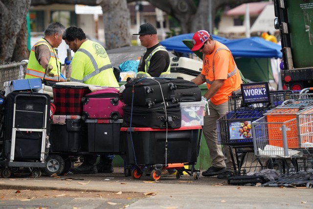 City and County workers assist in loading homeless belongings at Moiliili Neighborhood park.