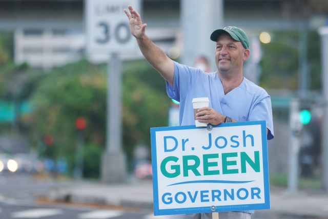 Gubernatorial candidate Dr. Josh Green campaigns and waves to drivers at the intersection of the Pali Highway and Vineyard.