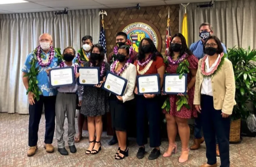 Honolulu Youth commissioners, from left to right: Cardenas Pintor, Pahonu Coleman, Gracie Kostecki, Kainoa Azama, Keziah Ancheta, Ella Matsui and Trinity Silbanuz are sworn in with Mayor Rick Blangiardi, at far left and Council Chair Tommy Waters and Vice-Chair Esther Kiaʻāina in attendance at right. 