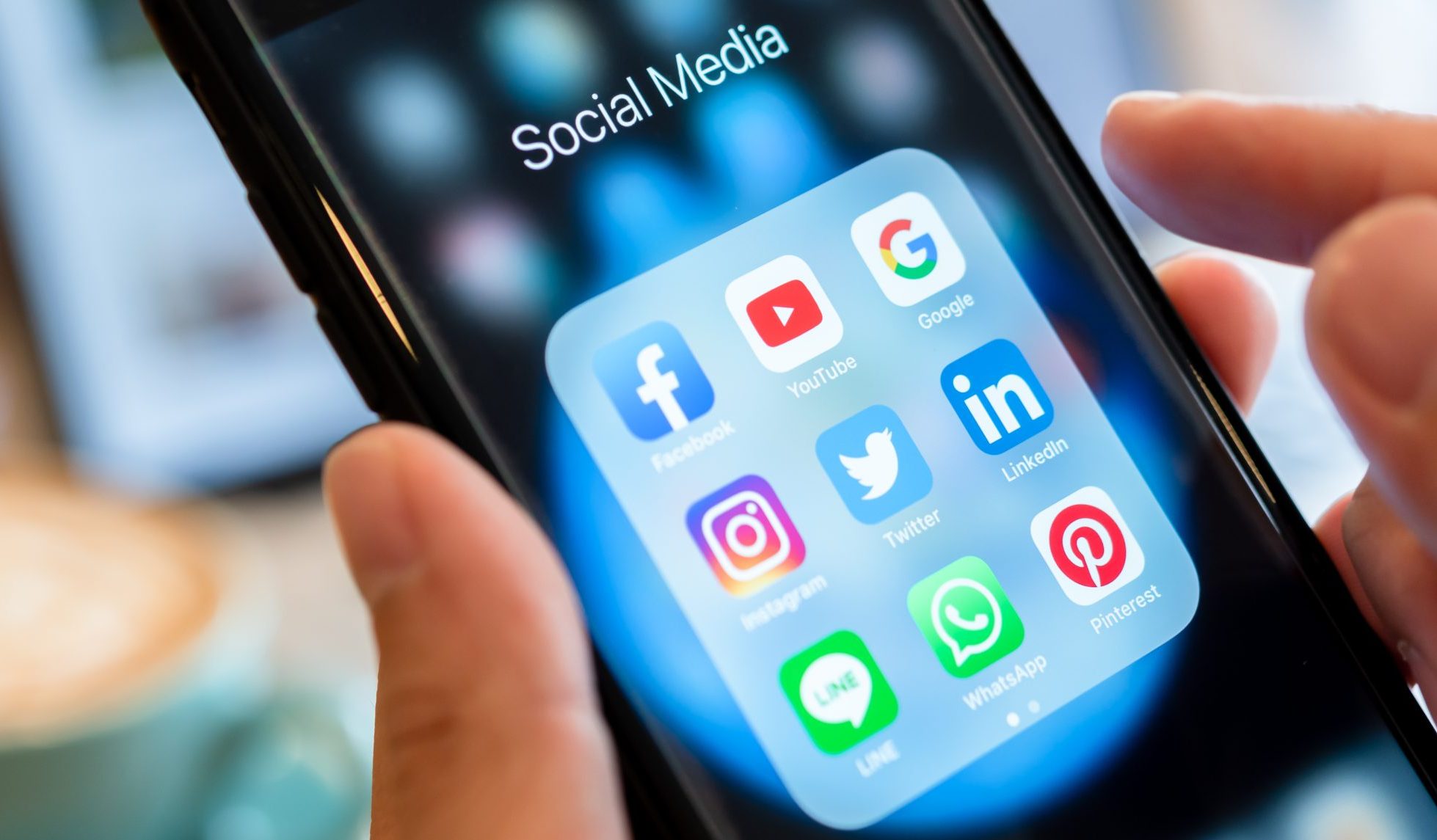 BANGKOK, THAILAND- 26 June 2019 : Hands of man use Iphone 7 plus with social media application of facebook, youtube, google search, instagram, twitter, linked in, line whatsapp, and pinterest on black background