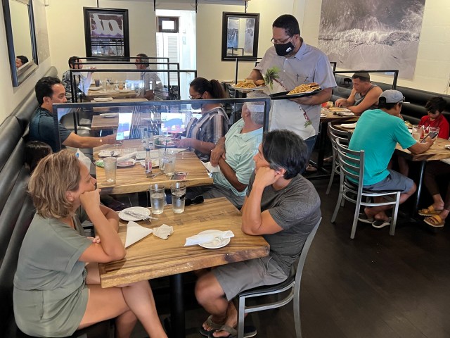 Waiter serving customers at te Surfing Pig restaurant in Kaimuki. Civilbeat Photos Ronen Zilberman. August 15, 2022.