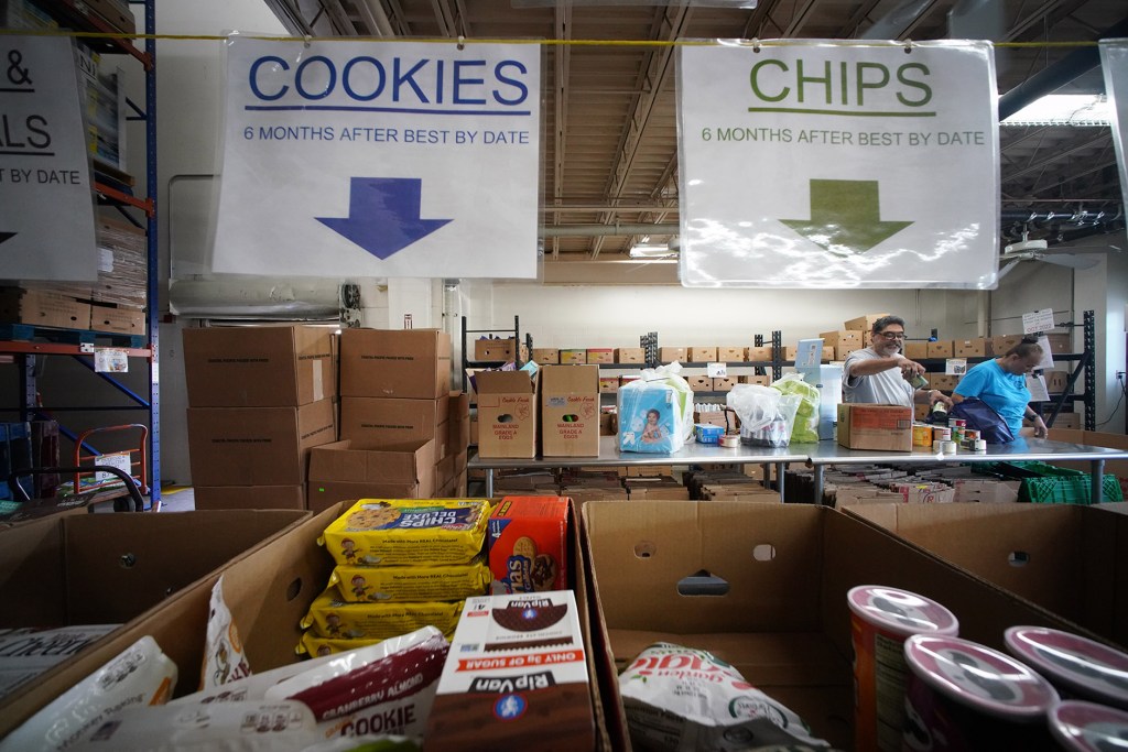 Workers assist in sorting packaged food at the Hawaii Foodbank warehouse located at 2611 Kilihau Street.