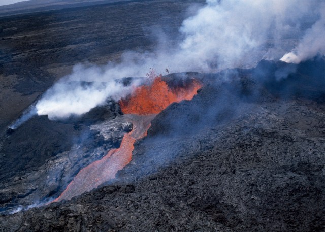 FILE - Molten rock flows from Mauna Loa, located on the south-central part of the island of Hawaii, on April 4, 1984. Hawaii officials are warning residents of the Big Island to prepare for the possibility that the world's largest active volcano may erupt given a recent spike in earthquakes at the summit of Mauna Loa. Scientists don't expect the volcano to erupt imminently, but officials are reminding people lava could reach some homes in just a few hours when it does. (AP Photo/File)