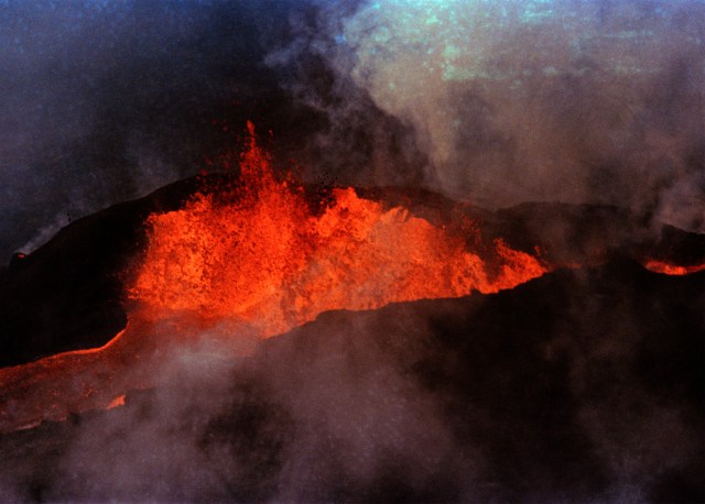 FILE - Molten rock flows from Mauna Loa on March 28, 1984, near Hilo, Hawaii. Hawaii officials are warning residents of the Big Island to prepare for the possibility that the world's largest active volcano may erupt given a recent spike in earthquakes at the summit of Mauna Loa. Scientists don't expect the volcano to erupt imminently, but officials are reminding people lava could reach some homes in just a few hours when it does. (AP Photo/Ken Love, File)