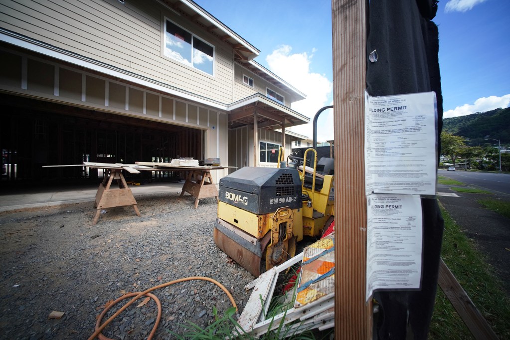 Construction near the 2400 block of Woodlawn Avenue with DPP permits flapping in the wind.