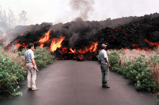 Concerned scientists observe an aa flow from Puu Oo as it advanced down a street in Royal Gardens subdivision on July 2, 1983. Photo by J.D. Griggs.