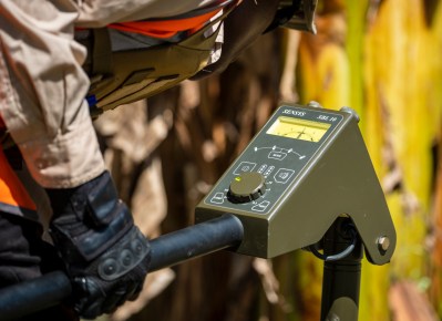 A metal detector is in the hand of a technician, who searches for unexploded bombs.