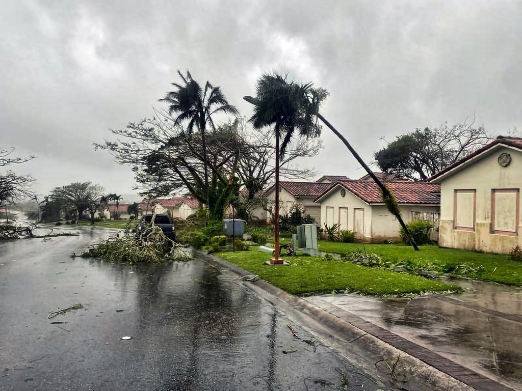 In this photo provided by the U.S. Coast Guard, downed tree branches litter a neighborhood in Yona, Guam, Thursday, May 25, 2023, after Typhoon Mawar passed over the island. The powerful typhoon smashed the U.S. territory of Guam and continued lashing the Pacific island with high winds and heavy rain Thursday, knocking down trees, walls and power lines and creating a powerful storm surge that threatened to wash out low-lying areas. (Chief Warrant Officer Adam Brown/U.S. Coast Guard via AP)