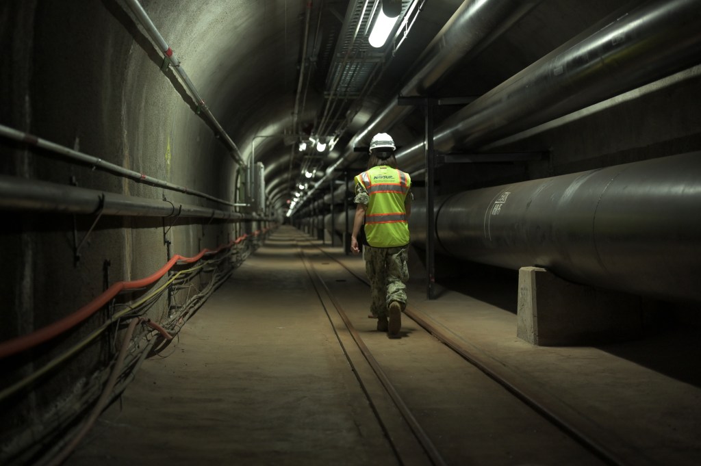 200717-N-TA290-1007 HONOLULU (July 17, 2020) Fuels director, LCDR Shannon Bencs walks a portion of the seven (7) miles of tunnels of the Red Hill Underground Fuel Storage Facility (U.S. Navy photo by Daniel Mayberry/Released)
