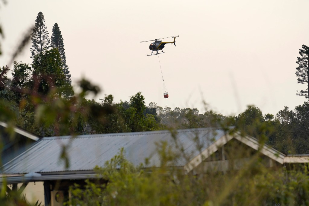 A helicopter with water bucket flies over Kula Wednesday, Aug. 9, 2023, on Maui. Smoke could be smelled, but there was no fire visible in the late afternoon. (Kevin Fujii/Civil Beat/2023)