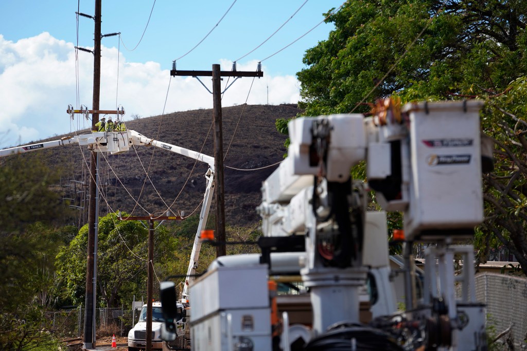 HECO crews work on utility lines mauka of the Lahaina Bypass Sunday, Aug. 13, 2023, in Lahaina. A large fire consumed areas of West Maui last week. Utilities have not been fully restored.  (Kevin Fujii/Civil Beat/2023)