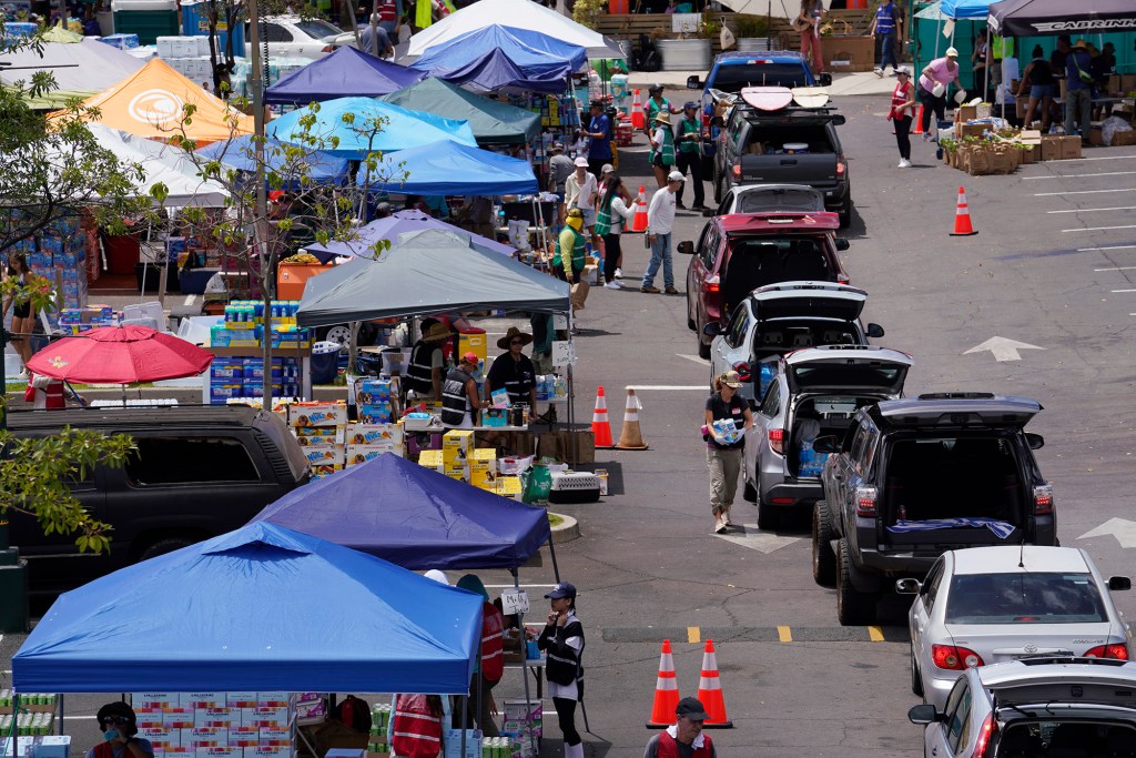 Donations and those in need of supplies form a serpentine queue at a shopping center Wednesday, Aug. 16, 2023, in Lahaina. A wildfire destroyed the historic town of Lahaina last week. (Kevin Fujii/Civil Beat/2023)