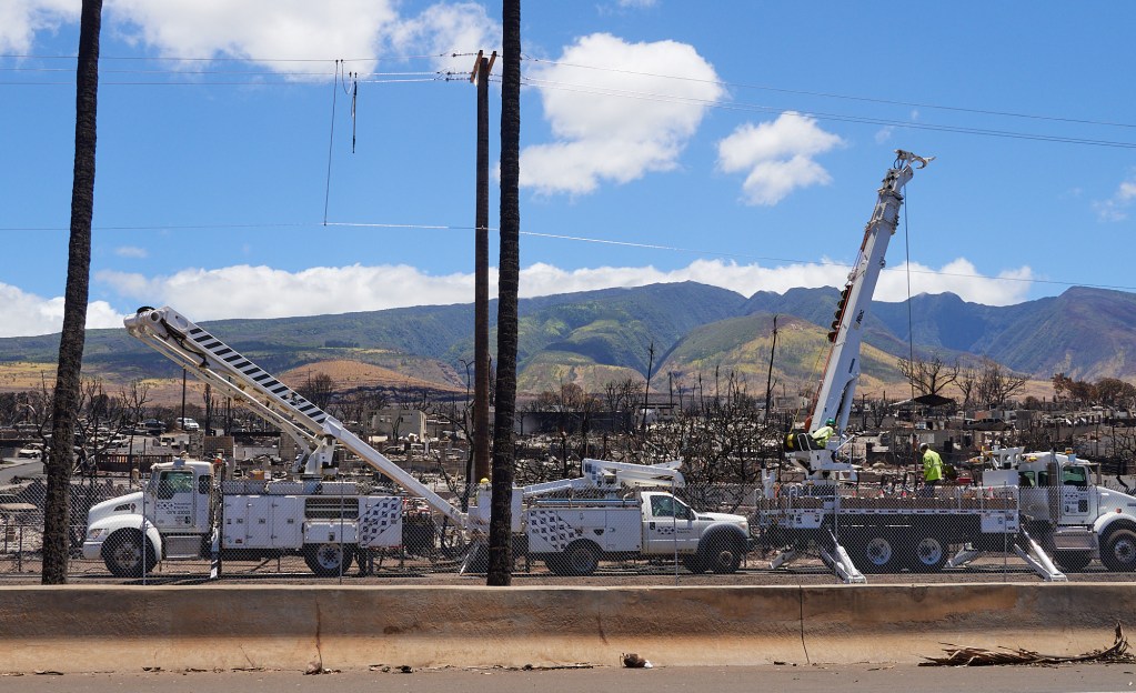 HECO trucks form a line under burned electric poles