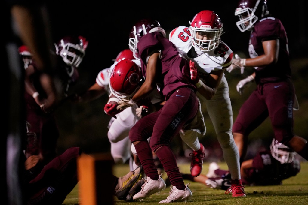 Lahainaluna High School running back James Lukela-Kobatake (33) helps Thomas Borges (7) cross the end zone to score a touchdown against Baldwin High School Saturday, Sept. 30, 2023, at War Memorial Stadium in Wailuku. The sold-out game paves the little way slowly back to normalcy after the devastating Aug. 8 fire. (Kevin Fujii/Civil Beat/2023)