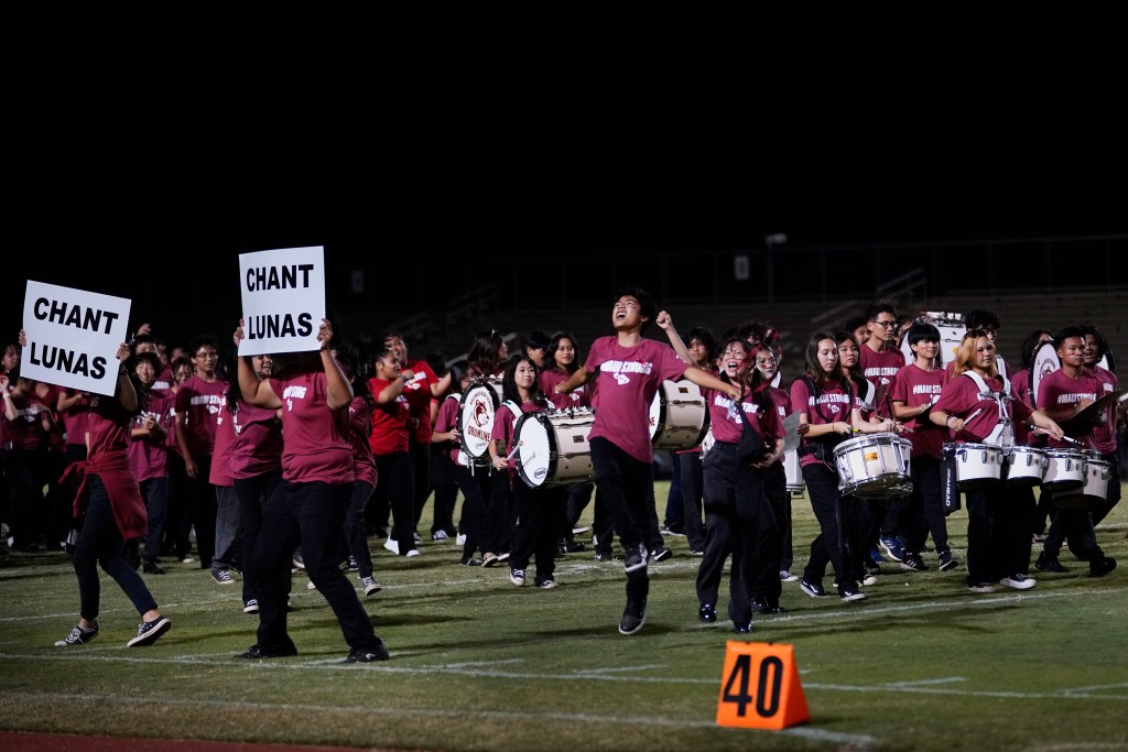 Baldwin High School marching band runs off the field after giving Lahainaluna High School’s marching band a check and their support during the Luna’s first football game of the season Saturday, Sept. 30, 2023, at War Memorial Stadium in Wailuku. The sold-out game paves the little way slowly back to normalcy after the devastating Aug. 8 fire. (Kevin Fujii/Civil Beat/2023)