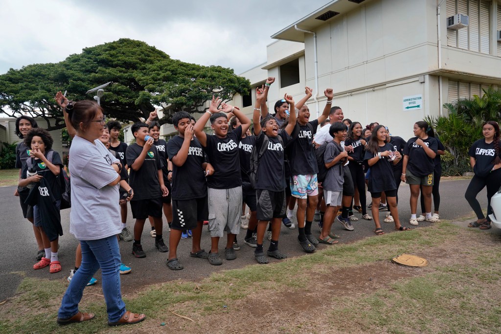 Washington Middle School students cheer for the arrival of four Los Angeles Clippers players Thursday, Oct. 5, 2023, in Honolulu. The LA Clippers Foundation partnered with Hawai’i Tourism Authority and the Hawaii Department of Education to refurbish the school’s technology lab. (Kevin Fujii/Civil Beat/2023)