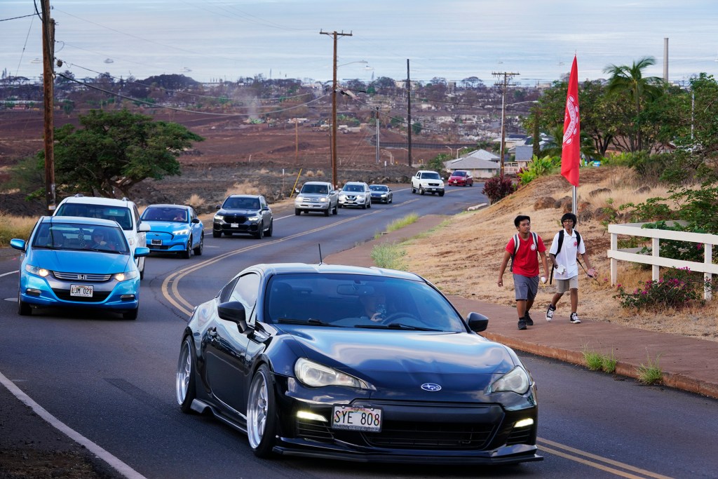 Cars line Lahainaluna Road as students return to Lahainaluna High School on the only paved road in and out of campus Monday, Oct. 16, 2023, in Lahaina. A new emergency road will offer a second route. The school has been closed since the Aug. 8 fire and studying at other schools in Maui. (Kevin Fujii/Civil Beat/2023)